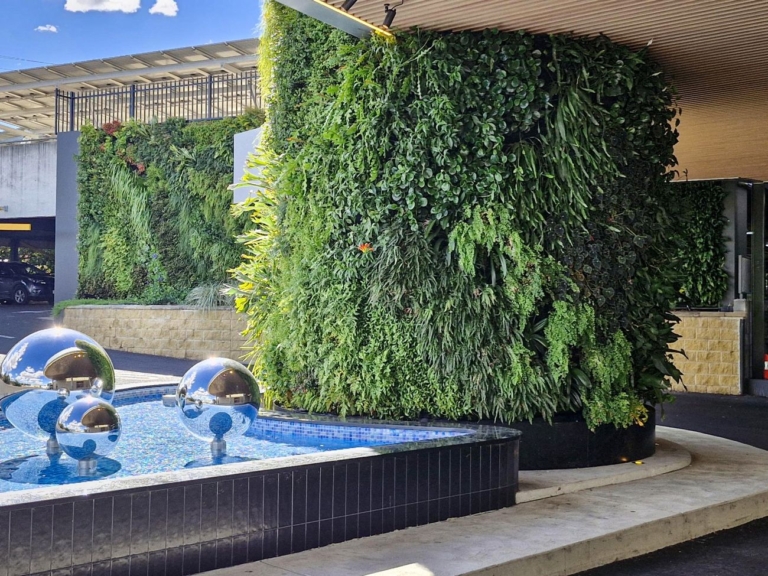 Mirror-polished 316 marine grade stainless steel spheres in the entry water feature at West Tamworth League Club, beside a green wall