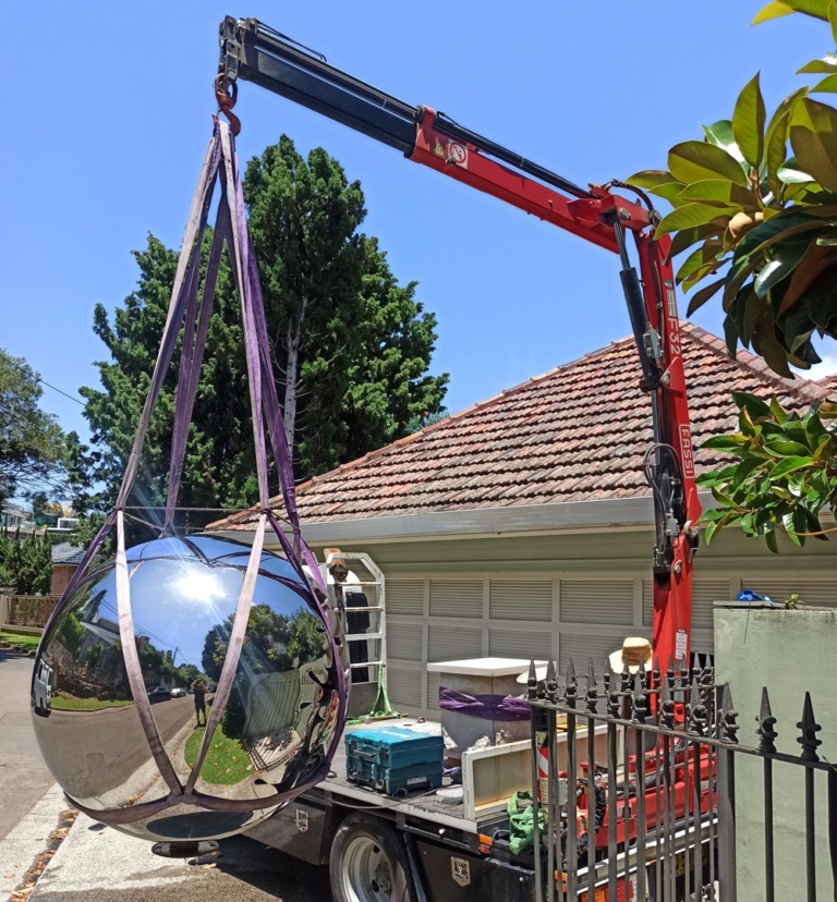 Nice Round Figure by David McCracken being lifted into place by truck crane